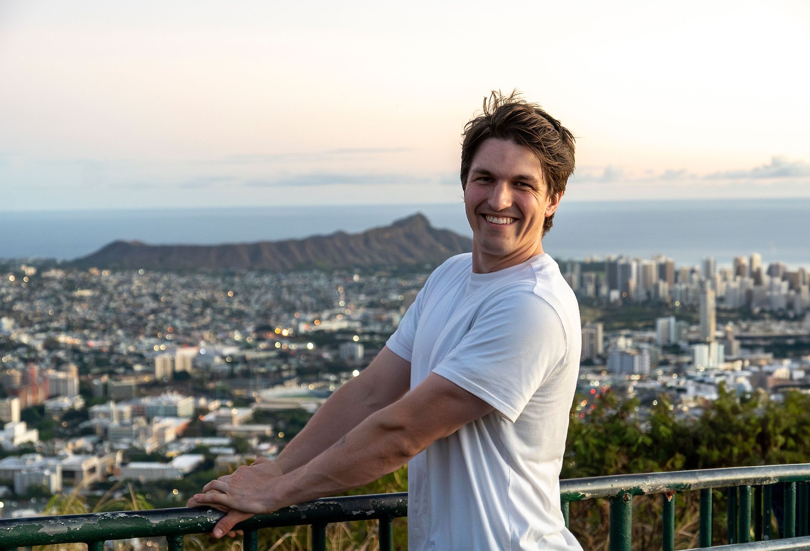 Student smiling with the cityscape of Honolulu in the background.