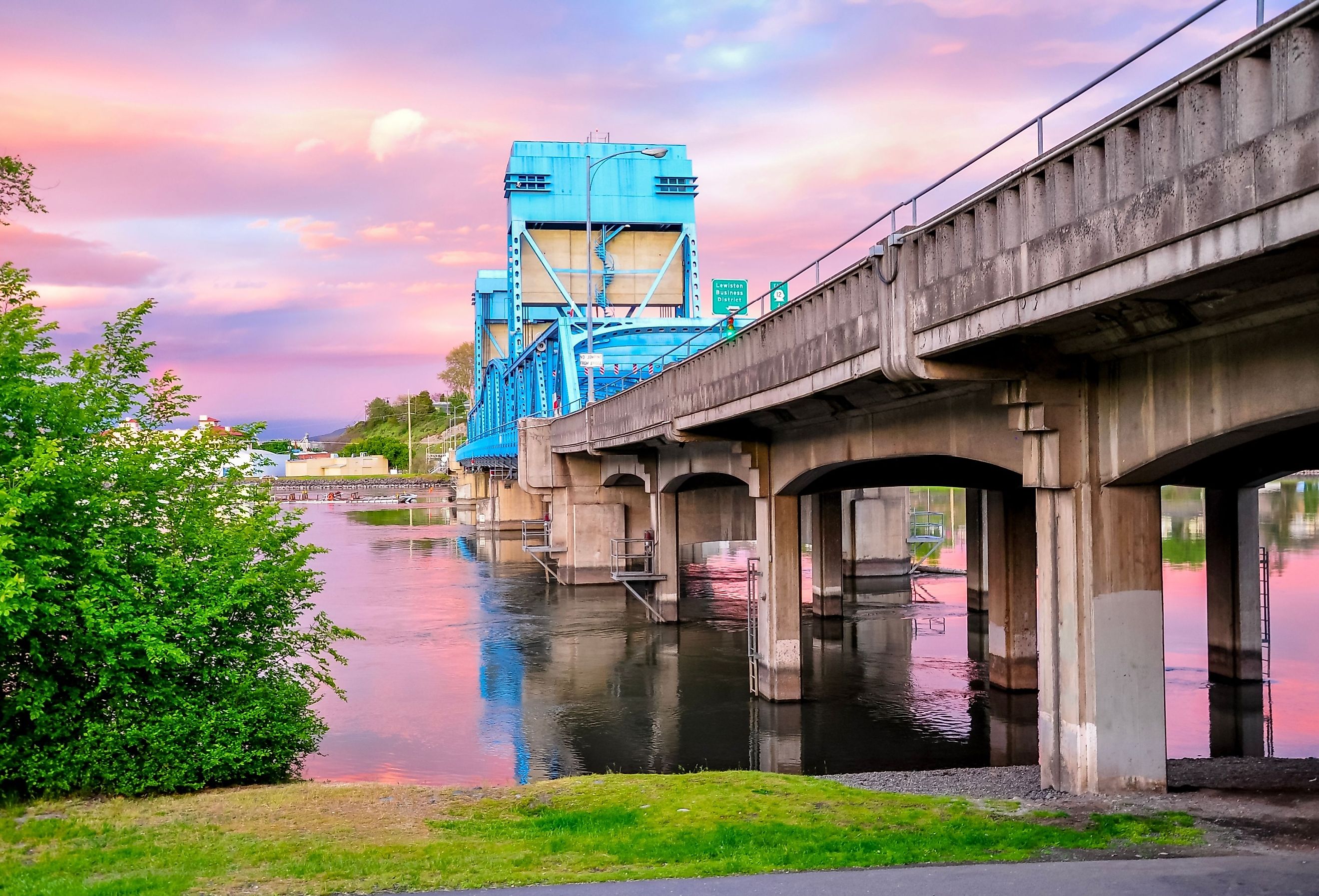 Historic Lewiston, Idaho with the Clarkston Blue Bridge against a pink sky.