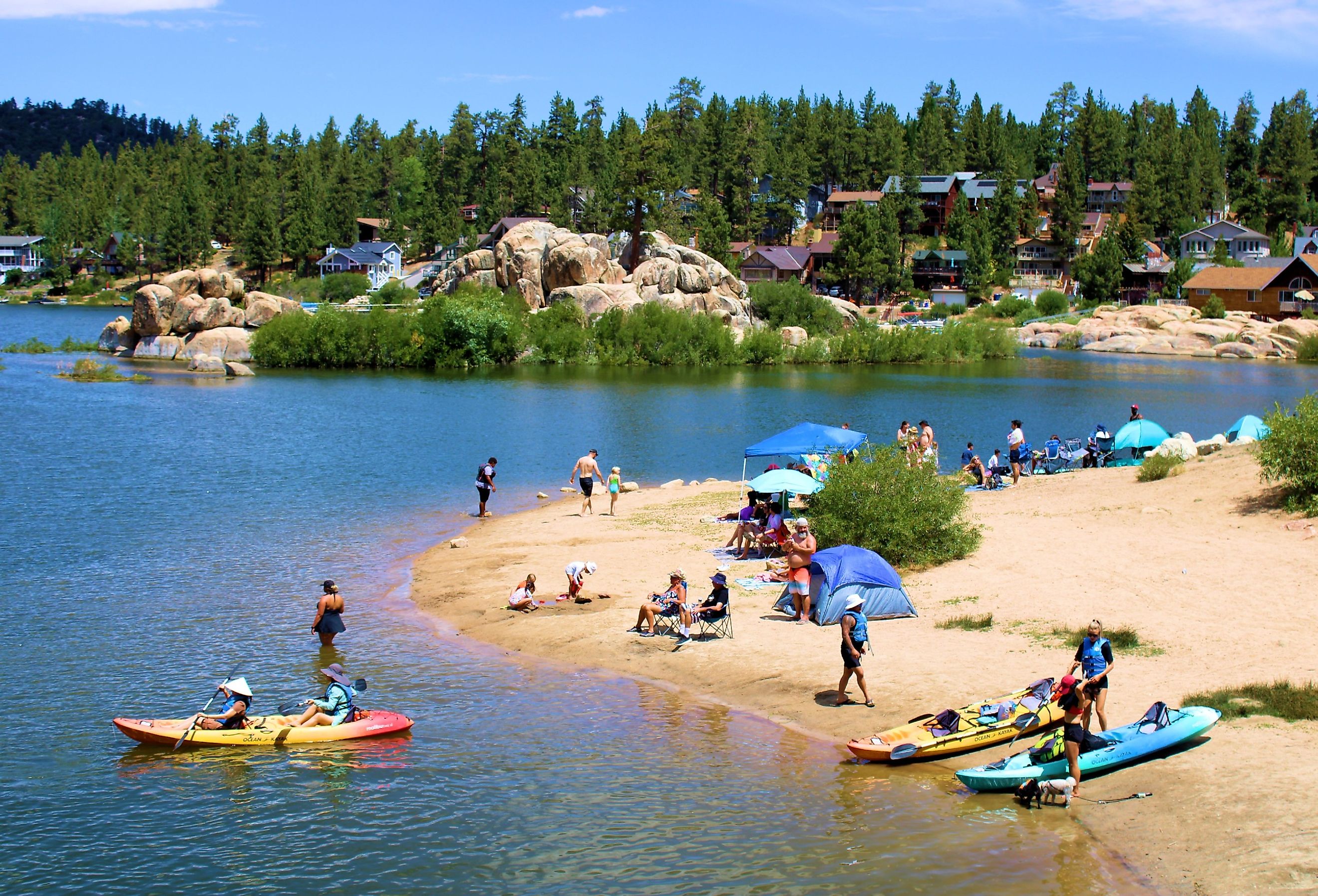 People kayaking besides a sandy beach cove in Big Bear Lake, California. Image credit photojohn830 via Shutterstock