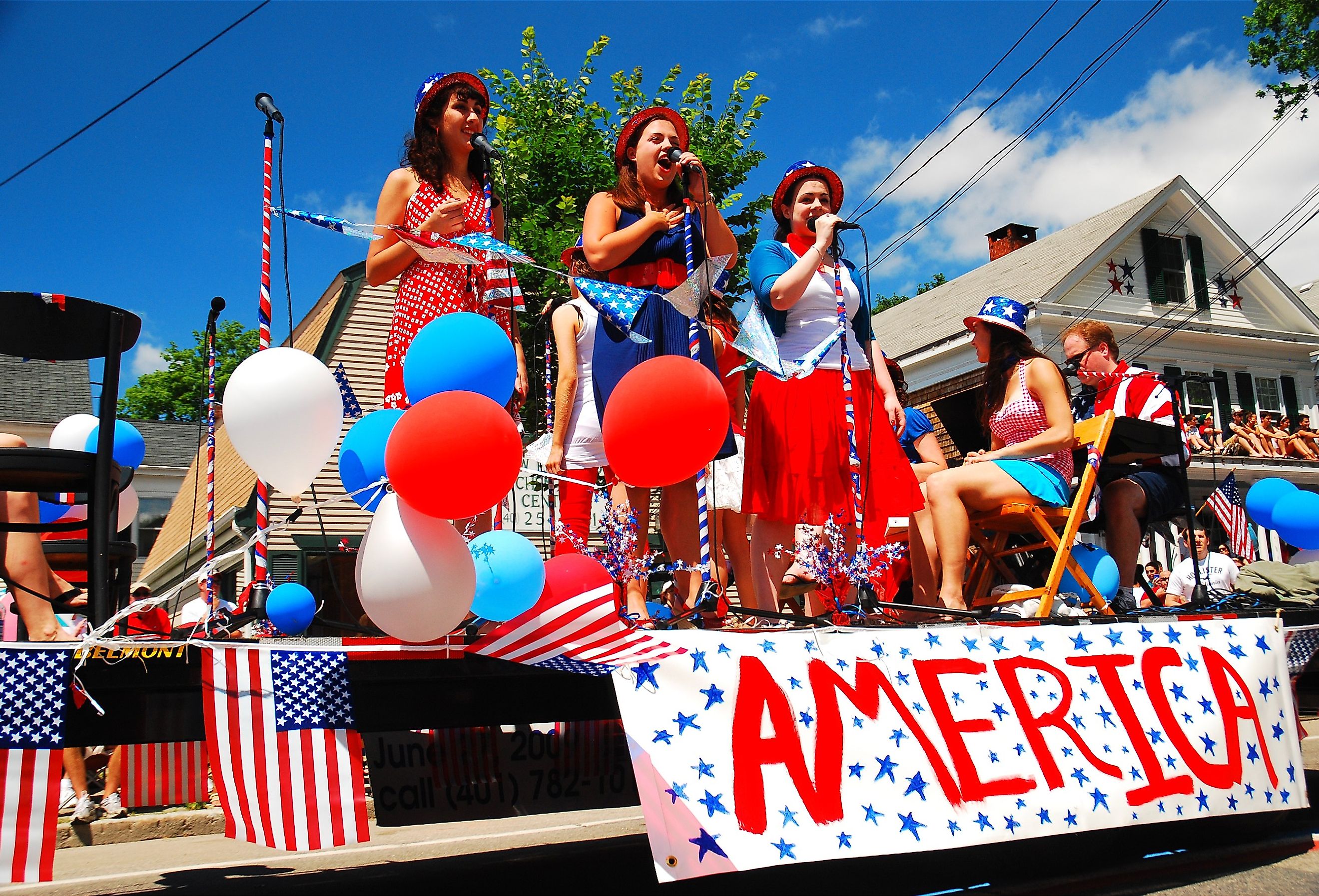 Three teenage girls sing during a Fourth of July parade in Bristol, Rhode Island. Image credit James Kirkikis via Shutterstock