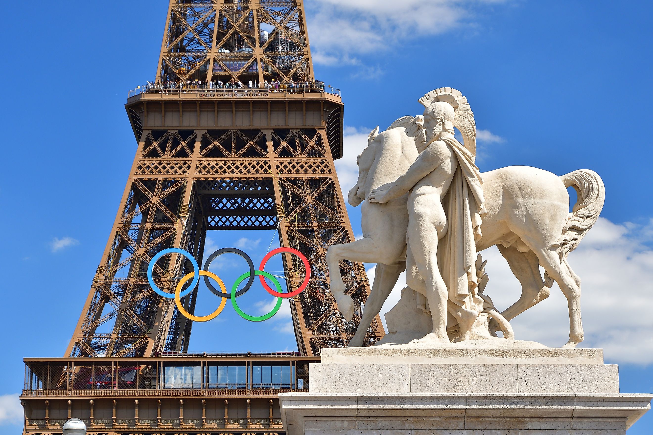 he statue on the Iéna Bridge and the Eiffel Tower adorned with the Olympic symbol. Image by noriox via Shutterstock.com